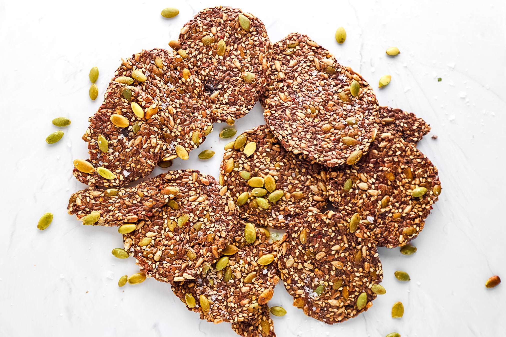 Artisan Ella’s Flats seed crackers, made with pumpkin, sesame, and flax seeds, gluten-free, keto-friendly, and perfect for charcuterie boards or heart-healthy snacking.